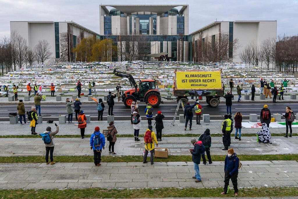 Bäuer:innen demonstrieren mit ihrem Traktor vor dem Kanzleramt für eine Agrarwende. Im Hintergrund 10.000 ausgedruckte Fußabdrücke, die Einzelpersonen eingeschickt haben.