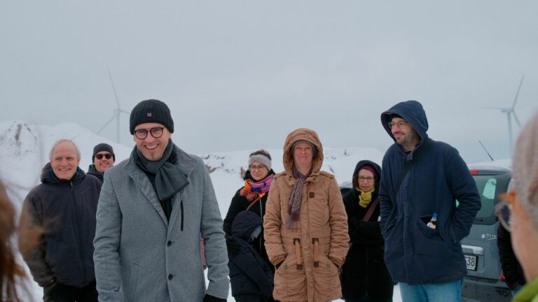Gruppe von Menschen im verschneiten Windkraftpark Sitten